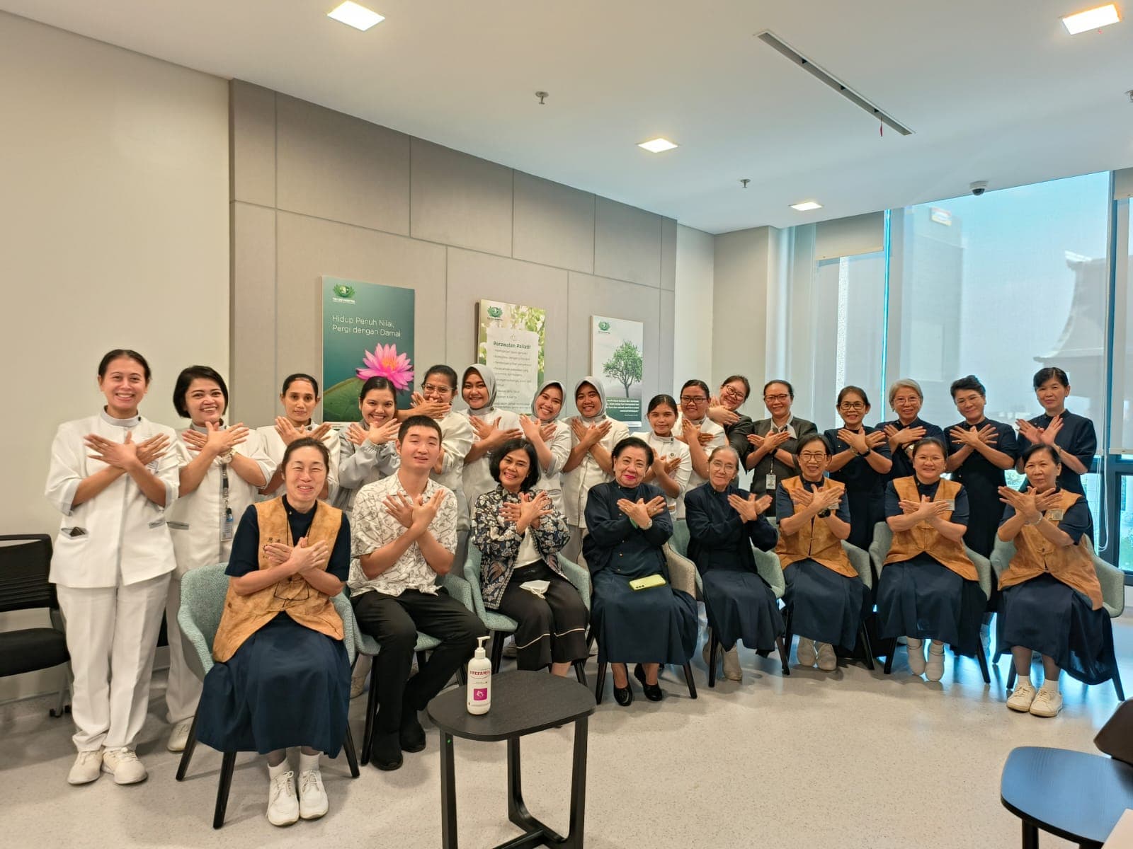 Tim Paliatif Tzu Chi Hospital berfoto bersama di depan latar 'Hidup Penuh Nilai, Pergi dengan Damai'